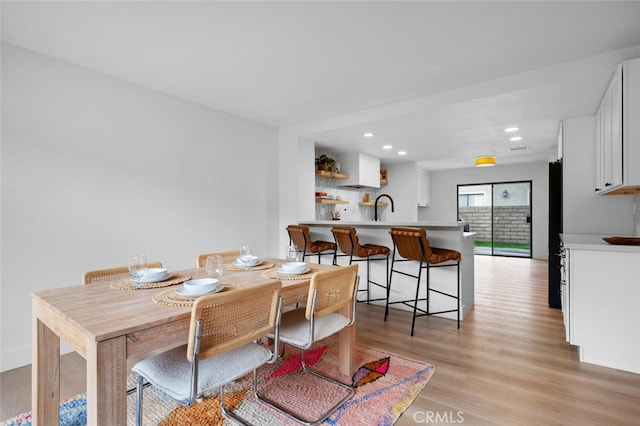 dining space featuring sink and light hardwood / wood-style flooring