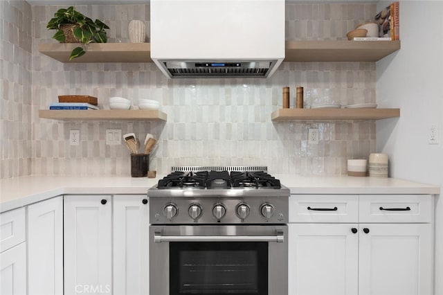 kitchen featuring gas range, decorative backsplash, custom exhaust hood, and white cabinets