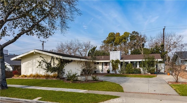 ranch-style house with a garage, concrete driveway, a front lawn, and a chimney