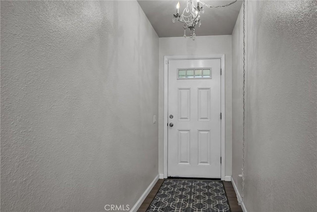 doorway to outside featuring dark hardwood / wood-style flooring and an inviting chandelier