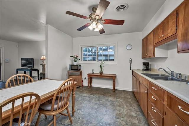 kitchen featuring ceiling fan and sink