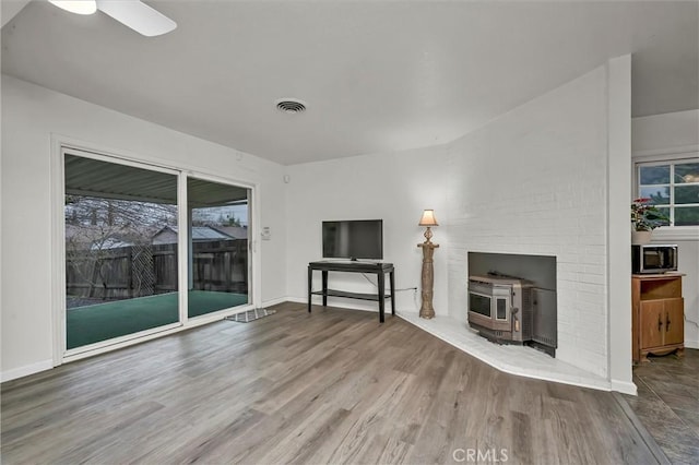 unfurnished living room featuring a healthy amount of sunlight, hardwood / wood-style floors, and ceiling fan