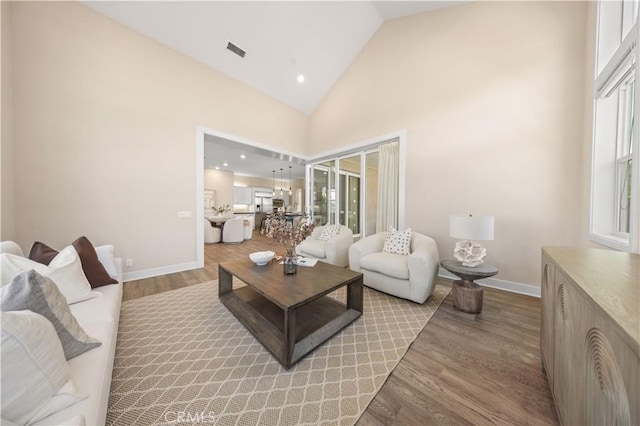 living room featuring light hardwood / wood-style flooring and high vaulted ceiling