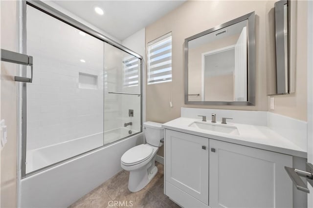 full bathroom featuring toilet, vanity, bath / shower combo with glass door, and tile patterned flooring