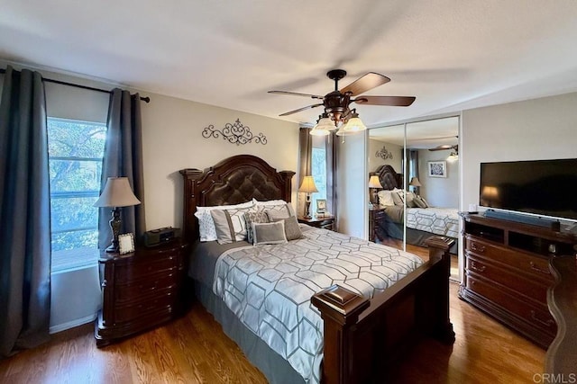 bedroom featuring hardwood / wood-style flooring, ceiling fan, and a closet