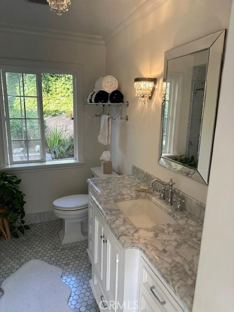 bathroom featuring toilet, ornamental molding, vanity, a notable chandelier, and tile patterned flooring