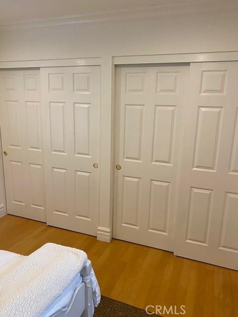 bedroom with crown molding and light wood-type flooring