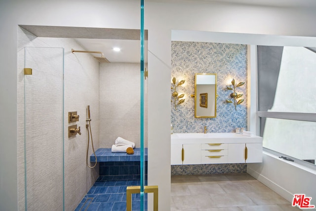 bathroom featuring vanity, tiled shower, and tile patterned floors