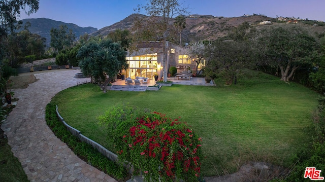 exterior space with a patio, a mountain view, and a yard