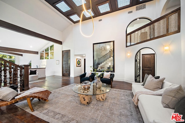 living room featuring hardwood / wood-style flooring, beam ceiling, and high vaulted ceiling