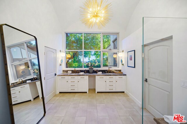 bathroom featuring vanity, lofted ceiling, and a notable chandelier