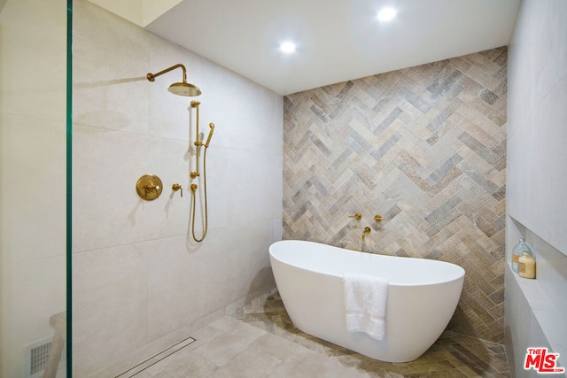 bathroom with tile walls and a bathing tub