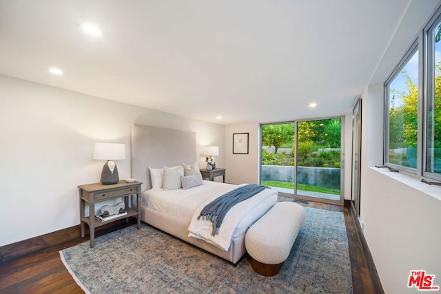 bedroom with multiple windows, access to outside, dark hardwood / wood-style floors, and a wall of windows