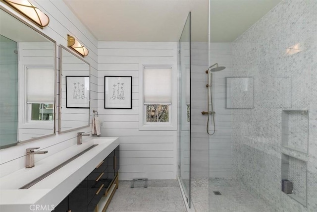 bathroom with vanity, wooden walls, and a shower with shower door