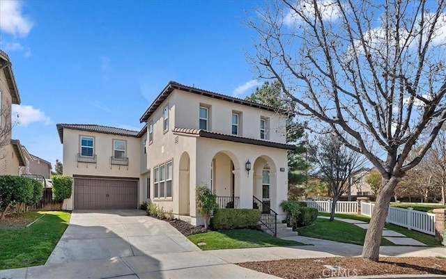 mediterranean / spanish house featuring a garage and a front yard