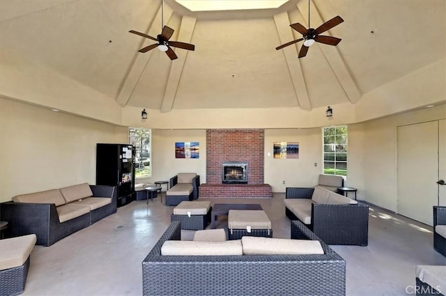 living room featuring concrete flooring, ceiling fan, high vaulted ceiling, and an outdoor brick fireplace