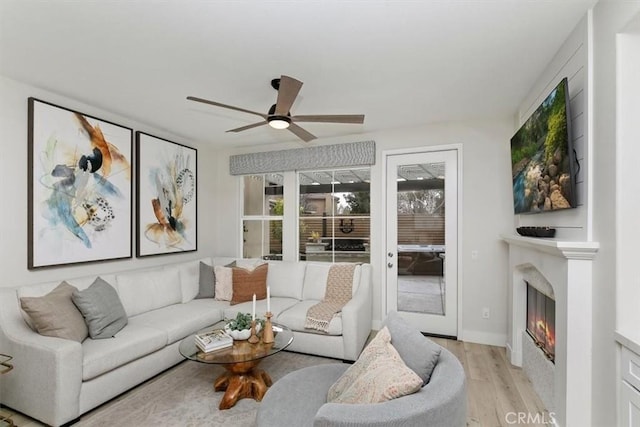 living room with ceiling fan and light wood-type flooring