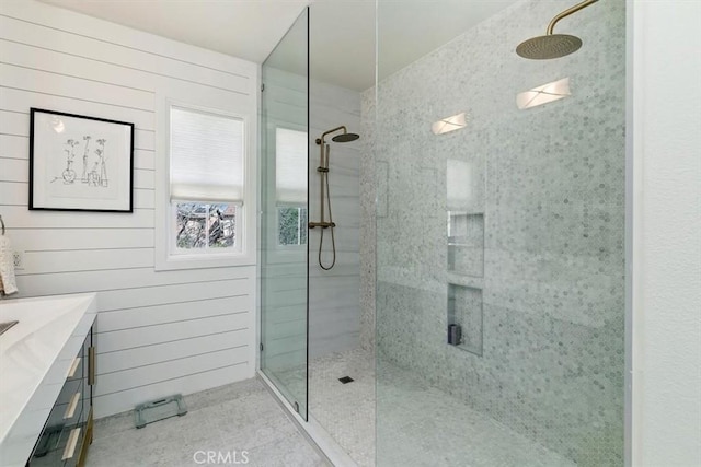 bathroom featuring an enclosed shower, vanity, and wood walls