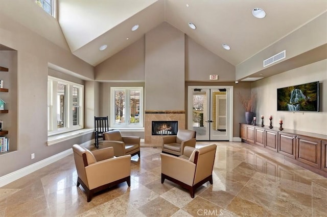 living room featuring a tiled fireplace and high vaulted ceiling