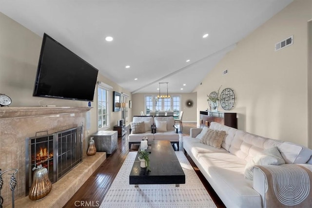 living room featuring a high end fireplace, dark wood-type flooring, and high vaulted ceiling