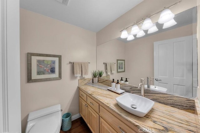 bathroom with vanity, hardwood / wood-style floors, and toilet