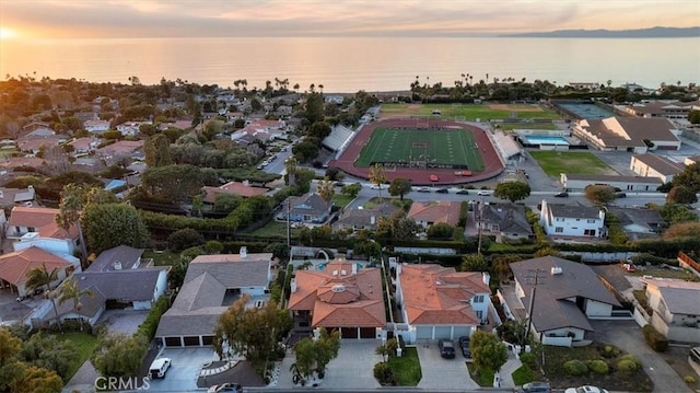 aerial view at dusk featuring a water view