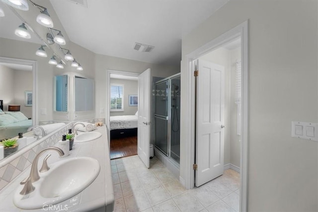 bathroom featuring tile patterned flooring, an enclosed shower, and vanity