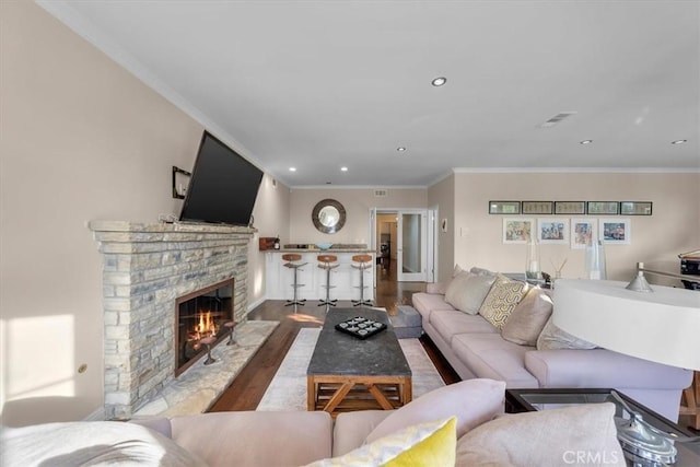 living room featuring hardwood / wood-style floors, crown molding, and a brick fireplace