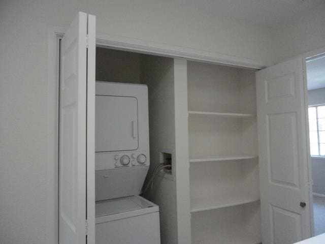 washroom featuring stacked washer / drying machine