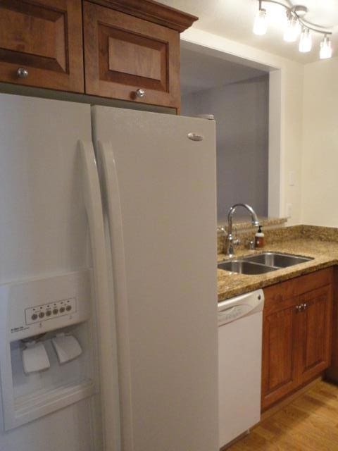 kitchen with sink, white appliances, and light hardwood / wood-style flooring