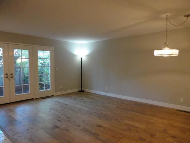 unfurnished room featuring french doors and hardwood / wood-style flooring