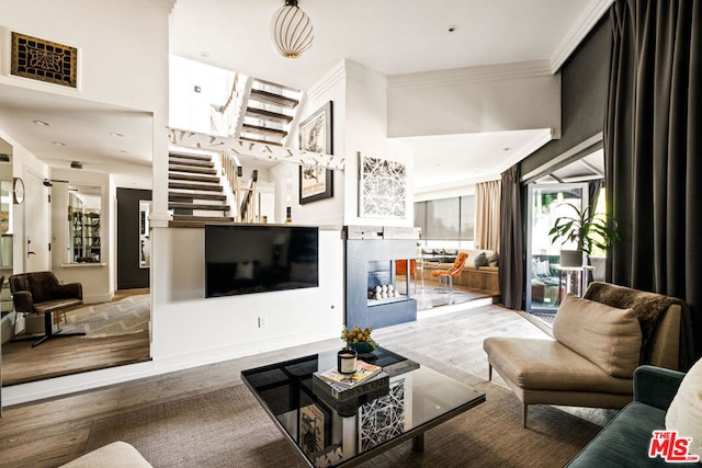 living room with crown molding and wood-type flooring