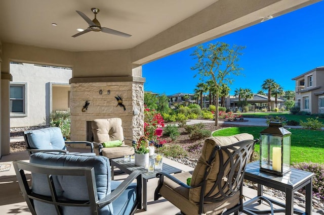 view of patio / terrace featuring an outdoor stone fireplace and ceiling fan