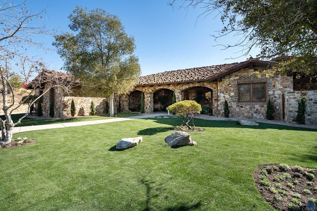 mediterranean / spanish home featuring a front yard