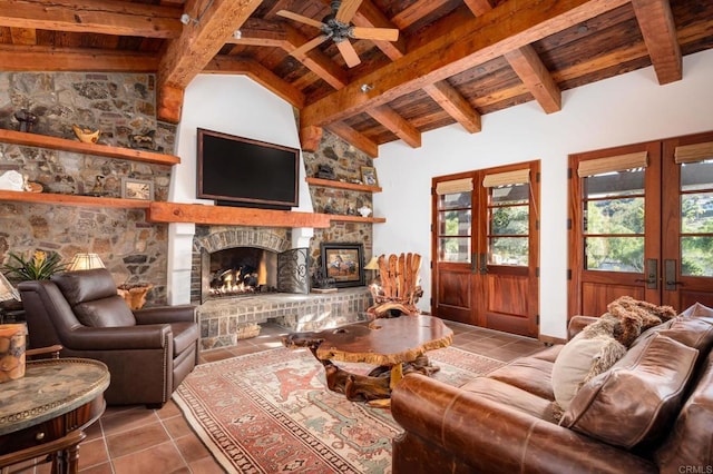 living room with ceiling fan, a fireplace, lofted ceiling with beams, wooden ceiling, and tile patterned floors