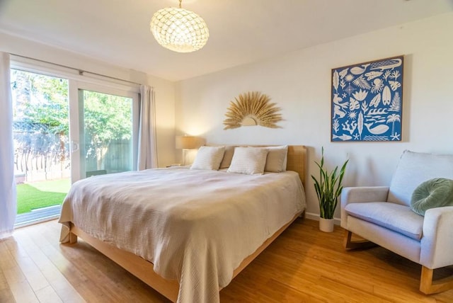 bedroom featuring access to exterior and light wood-type flooring