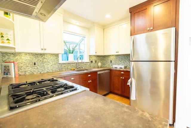 kitchen featuring white cabinetry, sink, backsplash, stainless steel appliances, and wall chimney exhaust hood