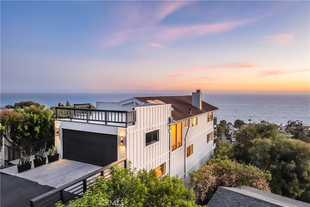 22332 Eagle Rock Way, Laguna Beach, CA 92651 - modern home featuring a chimney, a water view, board and batten siding, and driveway