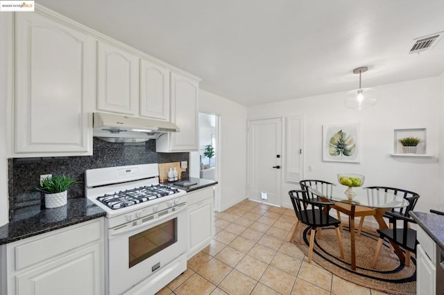 kitchen with light tile patterned flooring, tasteful backsplash, white cabinets, hanging light fixtures, and white gas range oven