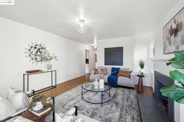 living room featuring hardwood / wood-style flooring and a brick fireplace