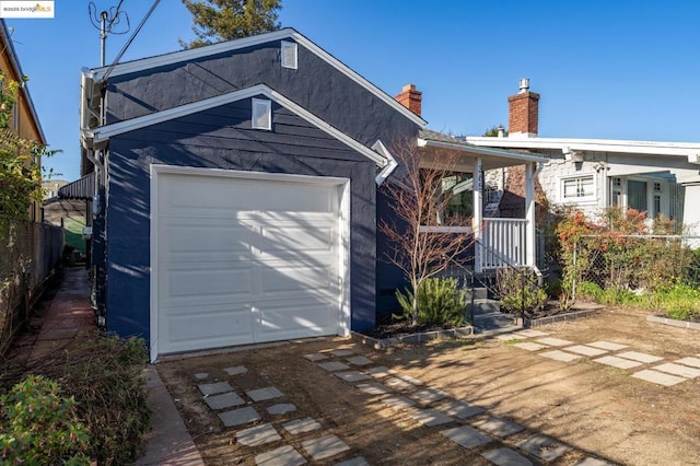 view of front of property with a garage, an outbuilding, and covered porch