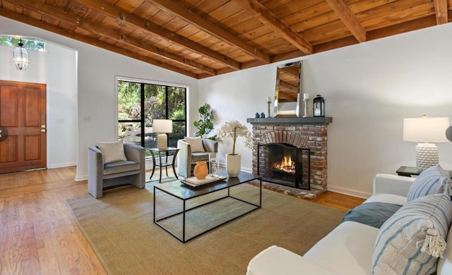 living room featuring wood ceiling, light hardwood / wood-style flooring, lofted ceiling with beams, a brick fireplace, and a chandelier