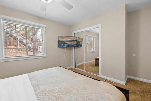 carpeted bedroom featuring multiple windows, a closet, and ceiling fan