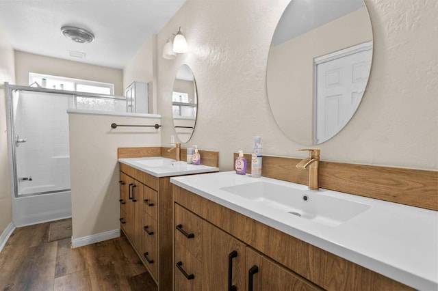 bathroom featuring vanity, wood-type flooring, and enclosed tub / shower combo