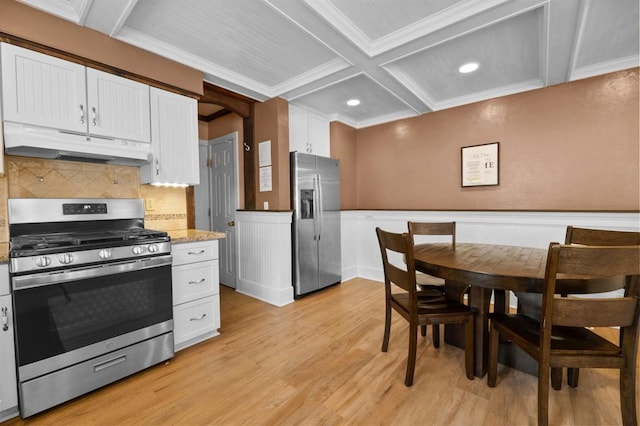 kitchen with coffered ceiling, white cabinetry, light stone counters, light wood-type flooring, and stainless steel appliances