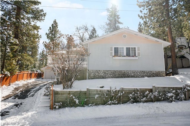 view of snowy exterior with a garage and an outdoor structure