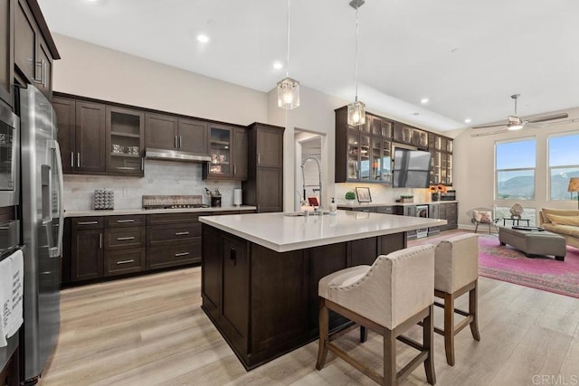 16750 Coyote Bush Dr Unit 107, San Diego, CA 92127 - kitchen with decorative backsplash, light countertops, appliances with stainless steel finishes, under cabinet range hood, and a sink