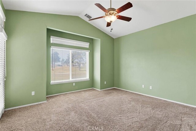 empty room featuring vaulted ceiling, carpet floors, and ceiling fan