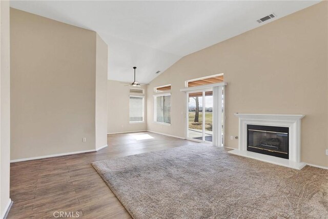 unfurnished living room featuring ceiling fan, lofted ceiling, and wood-type flooring