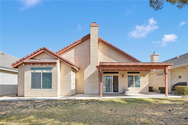 back of house featuring a patio area and a lawn